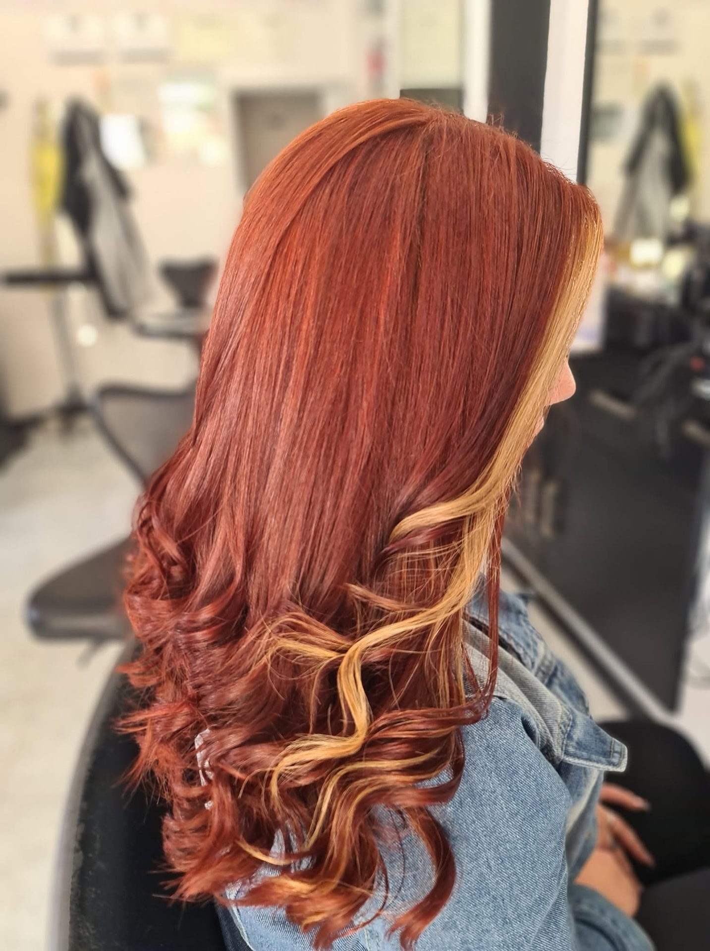 Long copper red hair with blonde highlighted curls styled at Hair Culture Rabat
